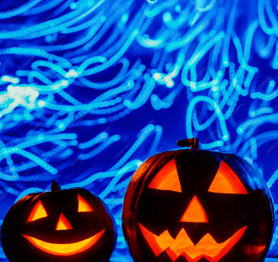 Deux citrouilles d’Halloween lumineuses devant des traînées bleues sous UV – atelier de peinture dans le noir à Paris