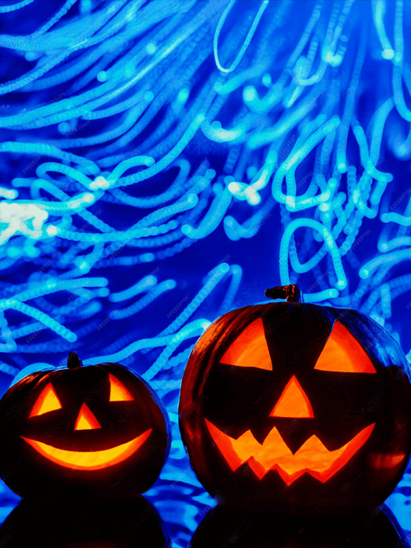Deux citrouilles d’Halloween lumineuses devant des traînées bleues sous UV – atelier de peinture dans le noir à Paris